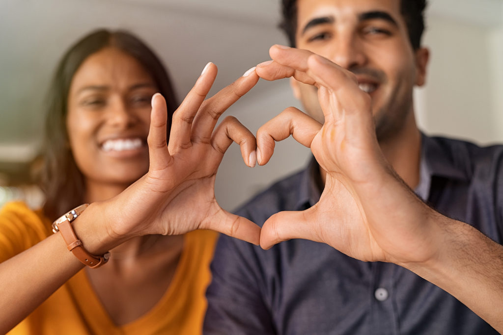 Photo d'un couple faisant un coeur avec ses mains